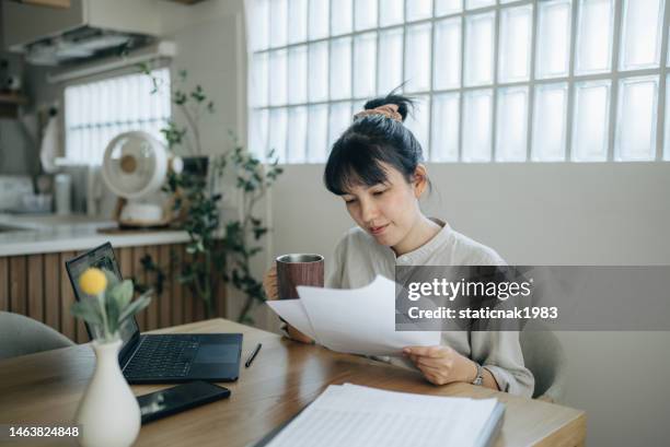 asian women working with invoices, calculates expenses doing work at home. - making money from home stock pictures, royalty-free photos & images