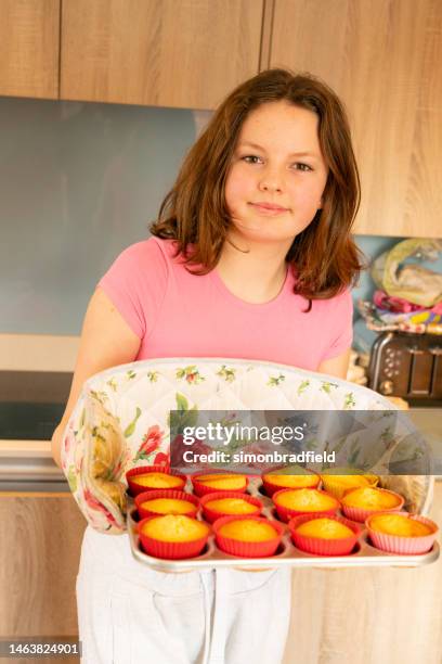 young girl baking cupcakes - simonbradfield stock pictures, royalty-free photos & images