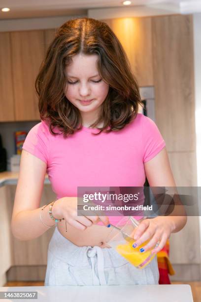 young girl baking cupcakes - simonbradfield stock pictures, royalty-free photos & images