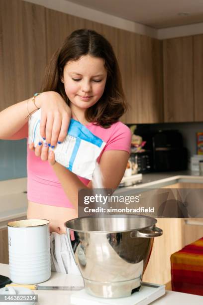 young girl baking cupcakes - simonbradfield stock pictures, royalty-free photos & images
