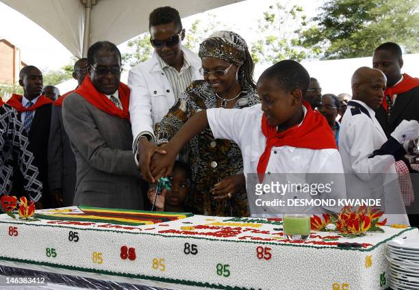 Zimbabwean President Robert Mugabe , his wife Grace , his son Robert Junior Mugabe and his youngest son Chatunga Mugabe cut his birthday cake in...