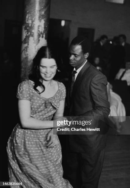 Couple dancing at Cy Laurie's jazz club, Blue Heaven, Soho, London, July 1954. She wears a spotted short-sleeved dress and he is in a dark suit and...