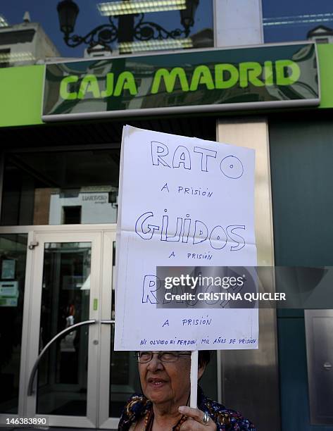 Woman holds a placard reading "Rato, Guindos and Rajoy, go to jail" during a demonstration in front of a Bankia office in Sevilla, on June 15, 2012....