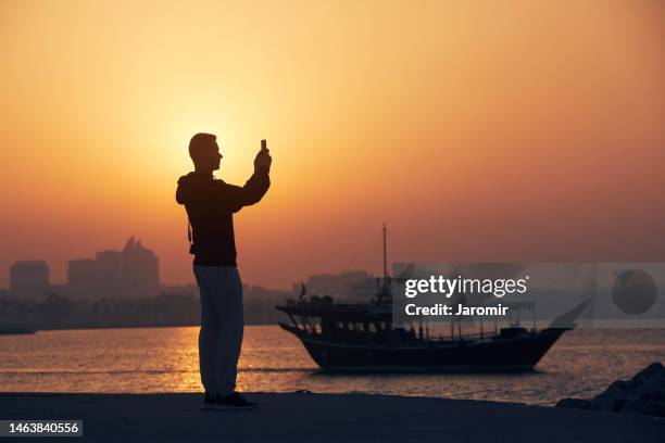 traveller on waterfronst against traditional boat - quayside stock pictures, royalty-free photos & images