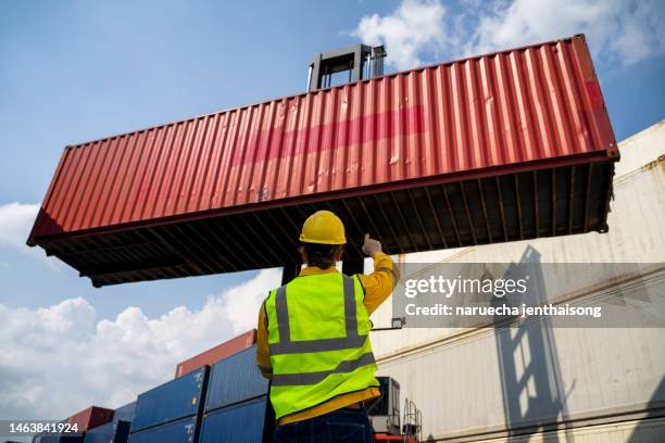 engineers are overseeing the transportation of cargo with containers inside the warehouse. business logistic and transportation concept. - contentor de carga imagens e fotografias de stock
