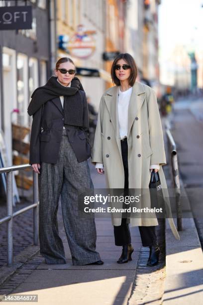 Guest wears black sunglasses, gold earrings, a white latte ribbed wool pullover, a dark gray ribbed wool large scarf, a dark gray blazer jacket, gray...