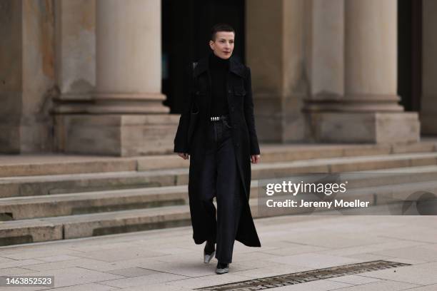 Tereza Brink is seen wearing silver earrings, Khaite leather shopper bag, Khaite black structure long coat, Agolde dark grey jeans, Khaite black...