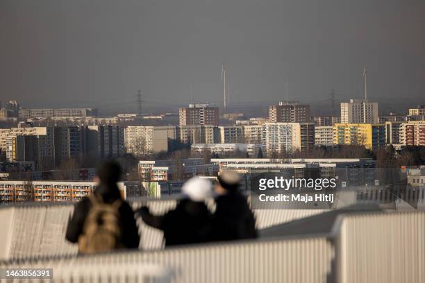People look out East Germany-era apartment buildings stand in Hellersdorf district on the eastern city outskirts on February 07, 2023 in Berlin,...