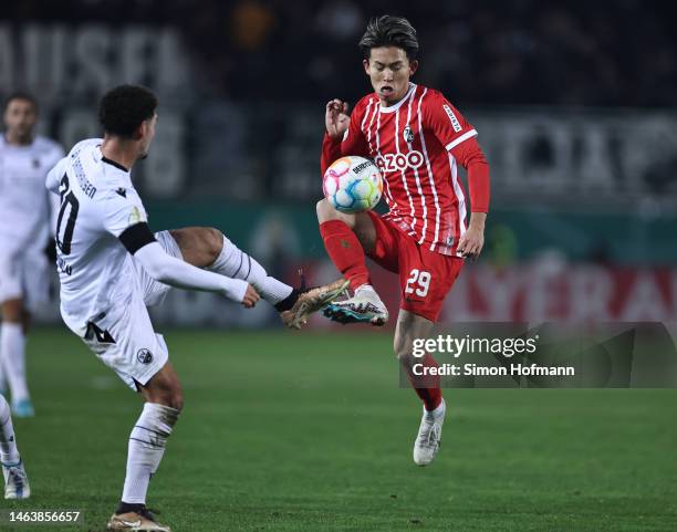 Jeong Woo-Yeong of Freiburg is challenged by Kerim Çalhanoglu of Sandhausen during the DFB Cup round of 16 match between SV Sandhausen and Sport-Club...