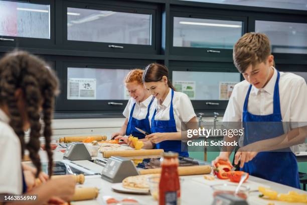 making pizza in pairs - home economics class stock pictures, royalty-free photos & images