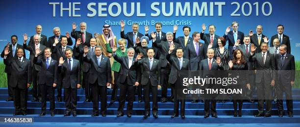 Attending members of the G20 group as well as invited guests wave as they pose together for the "family photo" following the plenary sessions at the...