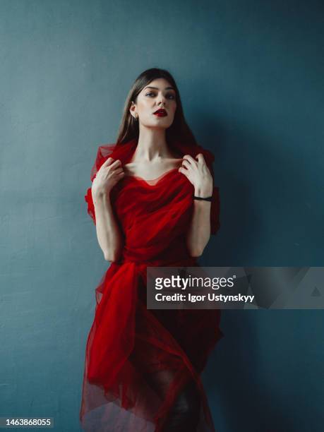 young serious woman in old-fashioned red dress - femme fatale stock-fotos und bilder