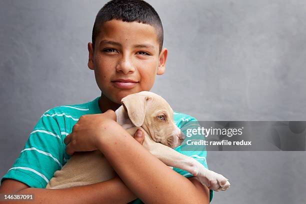 hispanic kid holding a puppy. - boy with dog stock pictures, royalty-free photos & images
