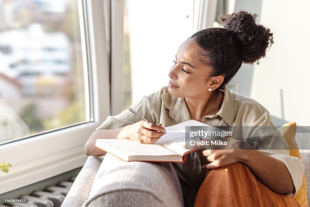 Junge afroamerikanische Frau schreibt Notizen