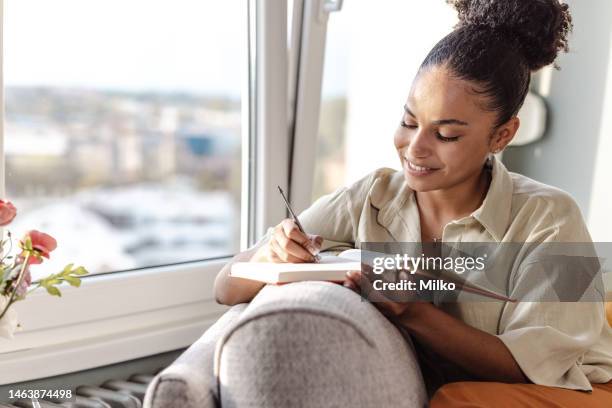 young african american woman writing notes - content writer stock pictures, royalty-free photos & images