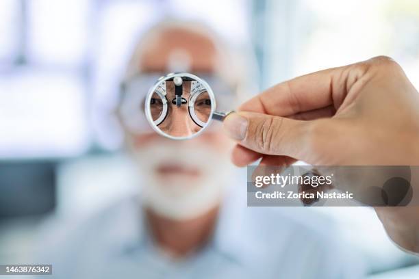 blick durch die linse nach brille beim optiker - lens eye stock-fotos und bilder