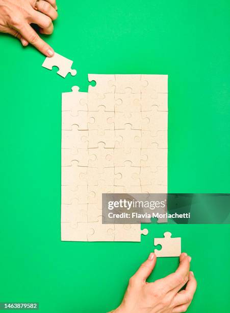 hands placing the last pieces of the puzzle - woman picking up toys stock pictures, royalty-free photos & images