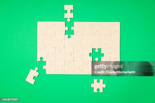 jigsaw with few pieces to fit - pièce de puzzle photos et images de collection