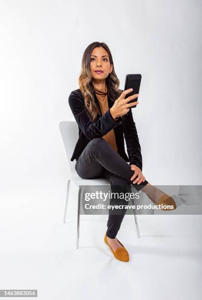 powerful portraits asian female on white background photo series - sitting and using smartphone studio stockfoto's en -beelden