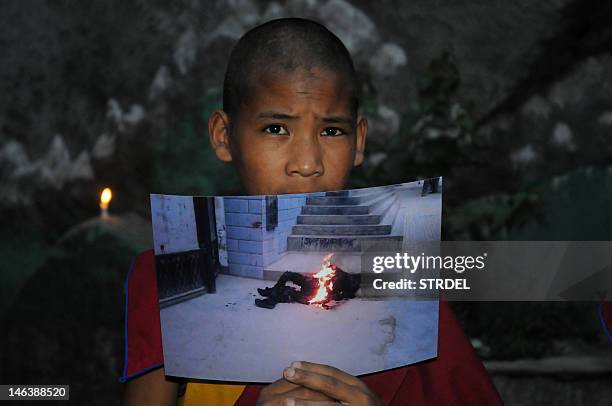 An exiled Tibetan monk holds a picture of 50-year-old, Tamdin Thar, who burned himself to death to protest against the Chinese rule in Tibet during a...