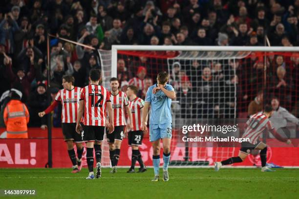 Max Cleworth of Wrexham looks dejected after failing to control the ball, as Billy Sharp of Sheffield United celebrates after scoring the team's...