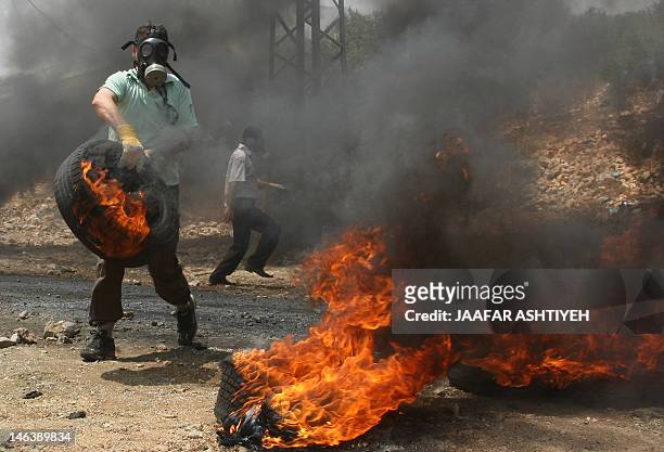 Palestinian protesters set car tyres on fire during a protest against the expropriation of Palestinian land by Israel in the village of Kafr Qaddum...