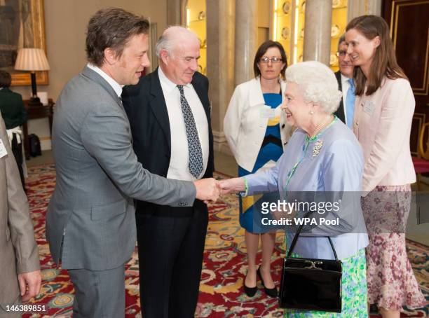 Queen Elizabeth II meets chefs Jamie Oliver and Rick Stein at a reception at Buckingham Palace on June 15, 21012 in London, England. Queen Elizabeth...