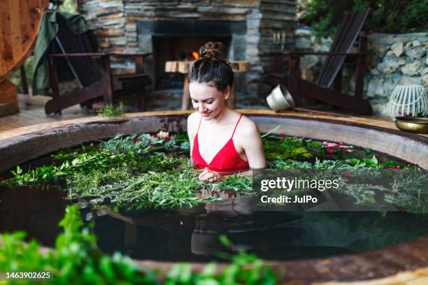 young woman relaxing in spa hotel in outdoor hot tube - red tub stock pictures, royalty-free photos & images