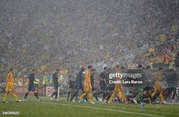 Players leave the pitch after play was suspended to due to weather during the UEFA EURO 2012 group D match between Ukraine and France at Donbass...