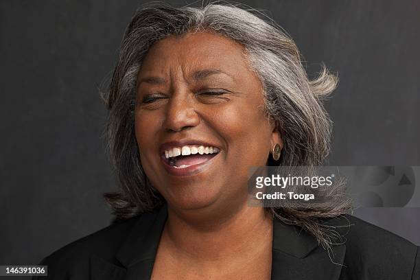 Tight portrait of senior laughing with closed eyes