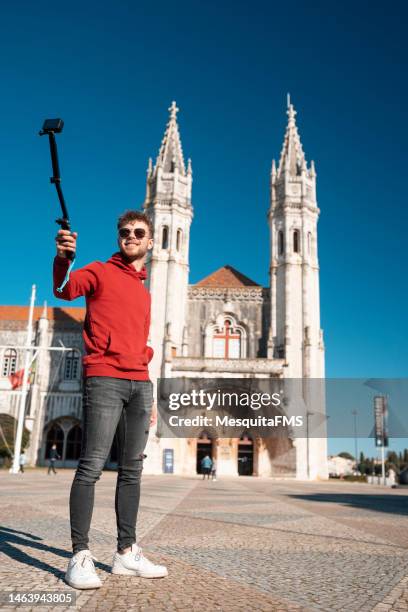 tourist taking a selfie in front of the jeronimos monastery in lisbon - art of the vintage selfie stockfoto's en -beelden