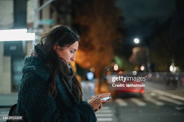checking apps on the go in the evening walk - williamsburg new york city stock pictures, royalty-free photos & images