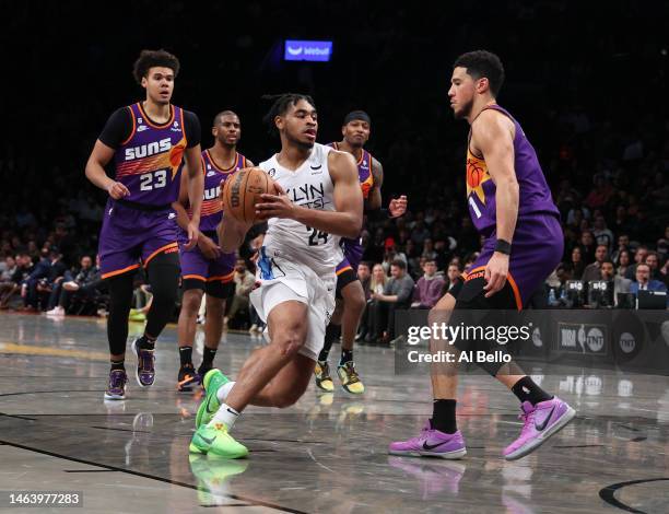 Cam Thomas of the Brooklyn Nets drives against Devin Booker of the Phoenix Suns during their game at Barclays Center on February 07, 2023 in New York...