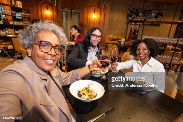 executives taking a selfie at a business dinner in a sophisticated restaurant - gala dinner stock pictures, royalty-free photos & images