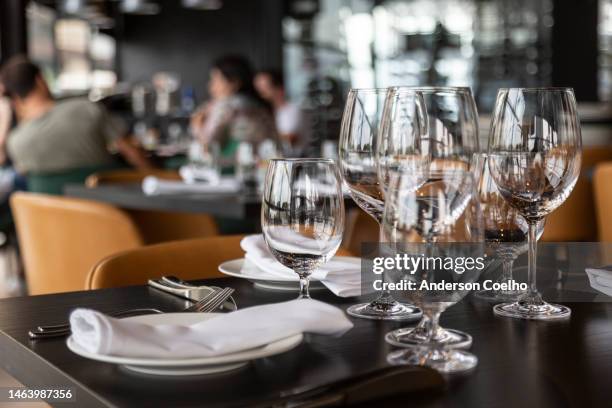 service of plates and glasses on a table in a sophisticated restaurant - gala table stock pictures, royalty-free photos & images