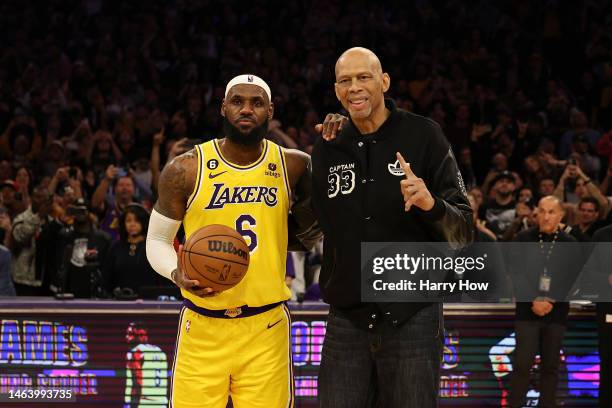 Kareem Abdul-Jabbar stands on court with LeBron James of the Los Angeles Lakers after James passed Abdul-Jabbar to become the NBA's all-time leading...