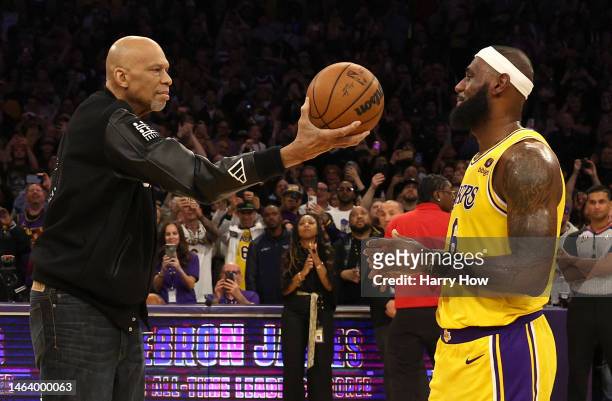 Commissioner Adam Silver looks on as Kareem Abdul-Jabbar ceremoniously hands LeBron James of the Los Angeles Lakers the ball after James passed...