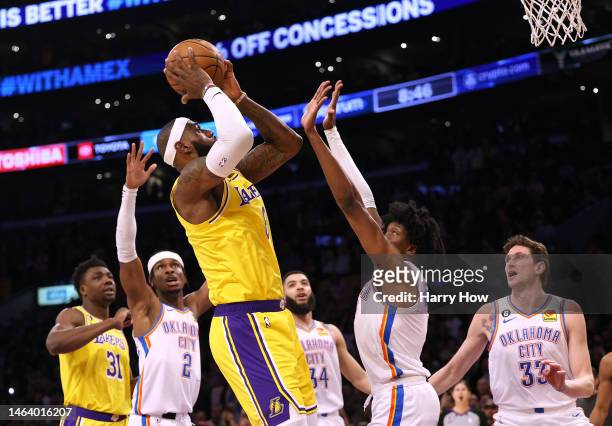 LeBron James of the Los Angeles Lakers attempts a shot in front of Jalen Williams of the Oklahoma City Thunder on his way to passing Kareem...