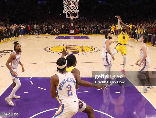 LeBron James of the Los Angeles Lakers scores on a jumper behind Kenrich Williams and Josh Giddey of the Oklahoma City Thunder to pass Kareem...