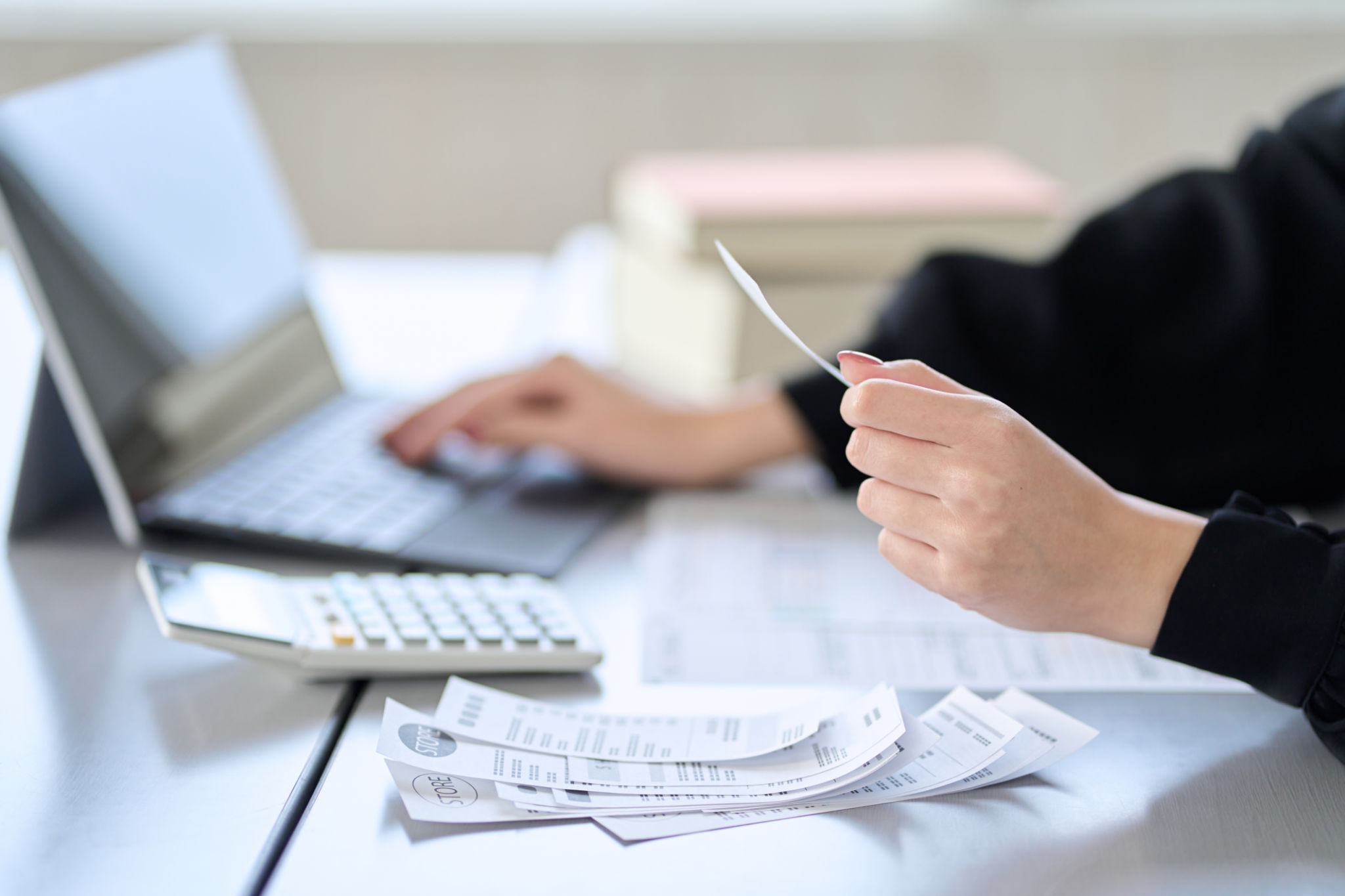 Asian woman entering expenses in accounting software Asian woman entering expenses in accounting software
