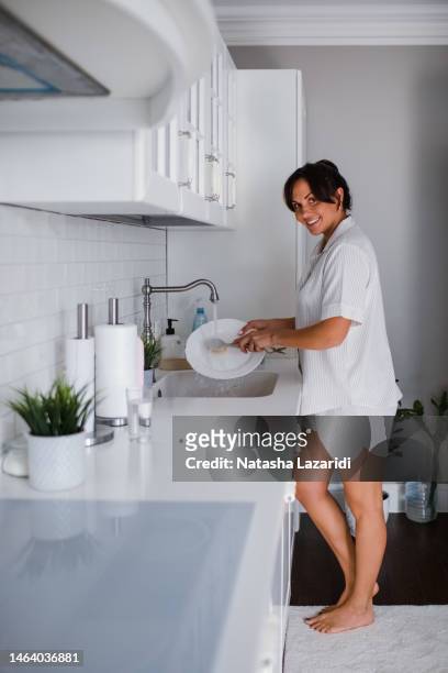 a woman washes dishes - cymbal water stock-fotos und bilder