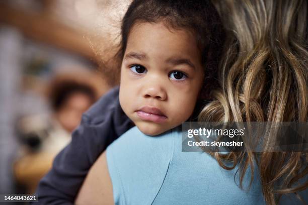 single mother consoling her adopted black girl at home. - sad mum stock pictures, royalty-free photos & images