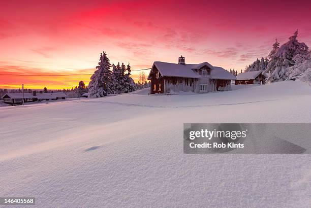 snow covered log cabins and firs at sunset - log cabin stock pictures, royalty-free photos & images