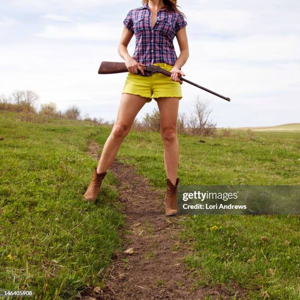 woman holding shotgun in summer field - calgary summer stock pictures, royalty-free photos & images