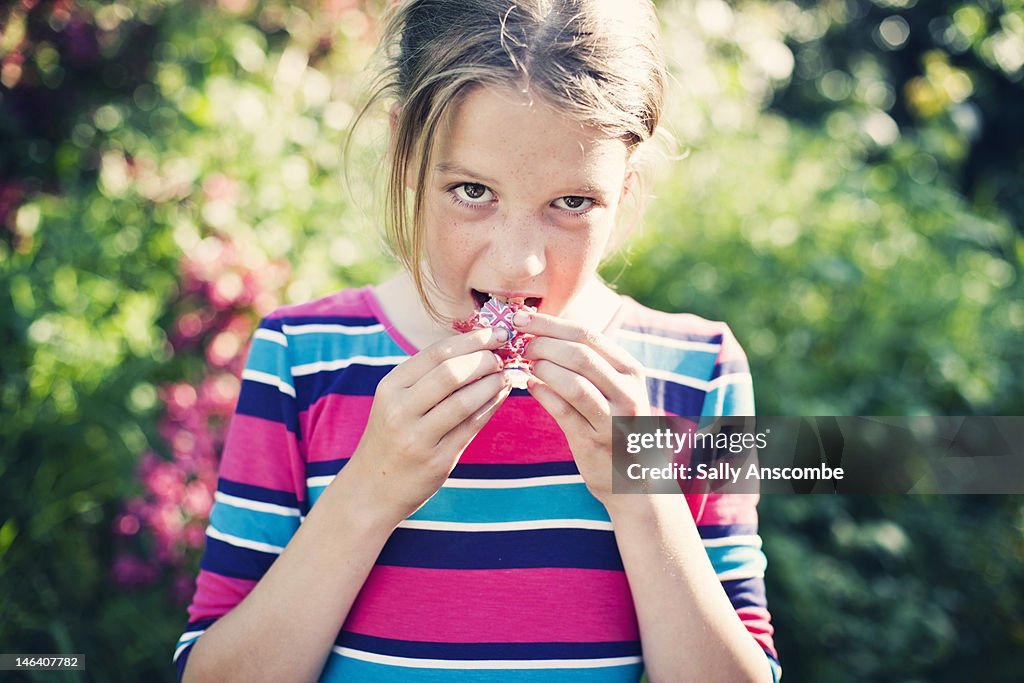 Young girl eating Union Jack cupcake