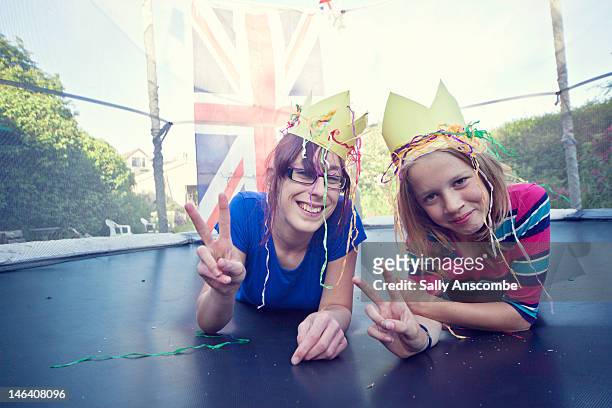 two happy smiling girls wearing crowns - british crown stock pictures, royalty-free photos & images