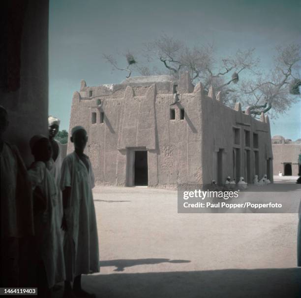 Men stand in front of and in the shade of the Emir's Palace in Kano, capital city of Kano State in northern Nigeria circa 1950. The current Emir of...