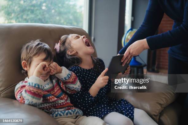 mother forbids her daughter and son to play game on digital tablet, concept for dependence on gadgets - hysteria imagens e fotografias de stock