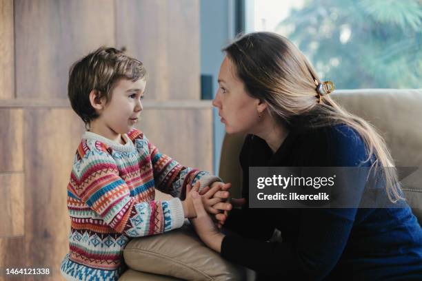 la madre consola il suo piccolo figlio triste - famiglia con figlio unico foto e immagini stock