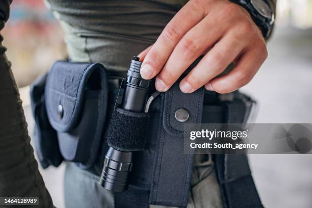 close-up of a young man standing in tactical gear - flashlight imagens e fotografias de stock